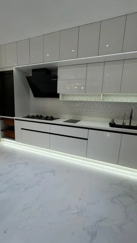Kitchen with handleless cabinets and marble flooring