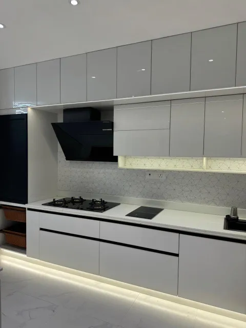 White gloss modular kitchen with chimney and hob