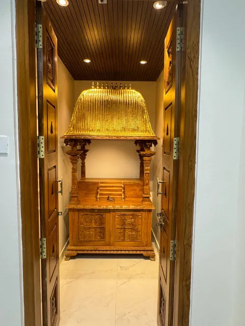 Pooja room with teak doors and wooden ceiling