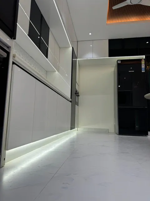 White hall with cove lighting and glossy storage units
